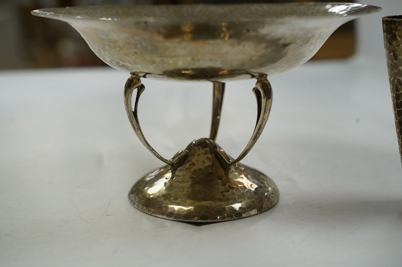 A George V Arts & Crafts planished silver bowl, on tripod supports and circular foot, Walker & Hall, Sheffield, 1912, diameter 15.7cm and a German planished vase inscribed 'Weihnachten 1897'. Condition - fair